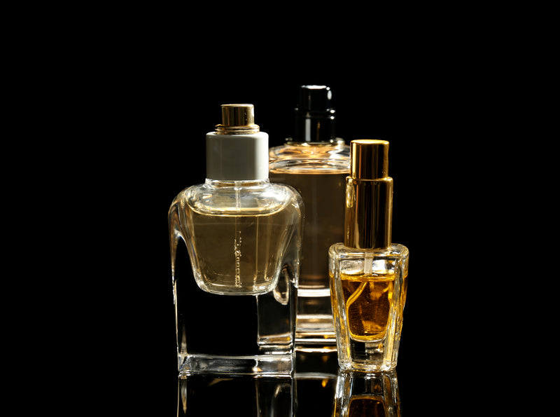 three perfume bottles on a black background